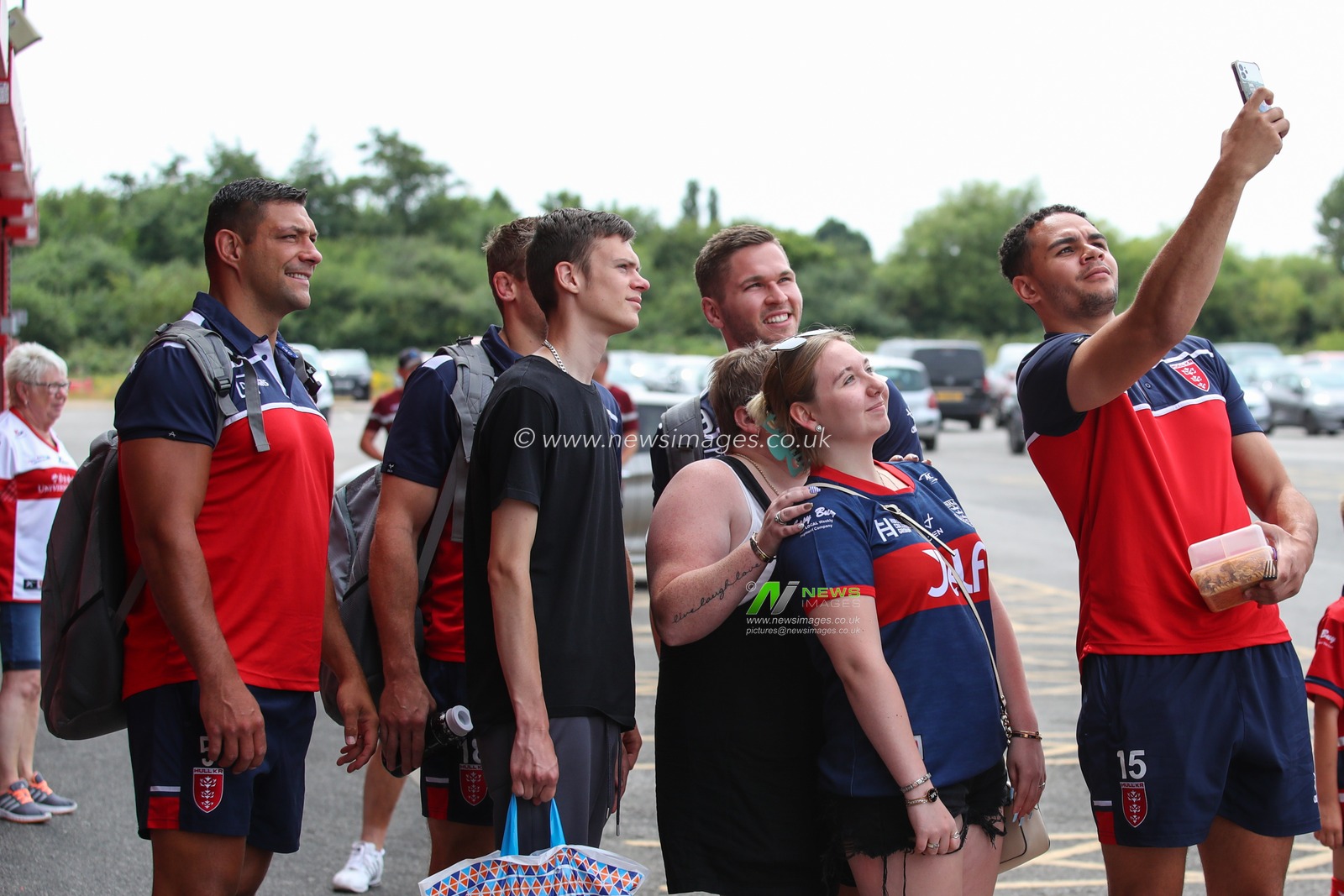 Hull Kingston Rovers players have a photograph taken with a fan