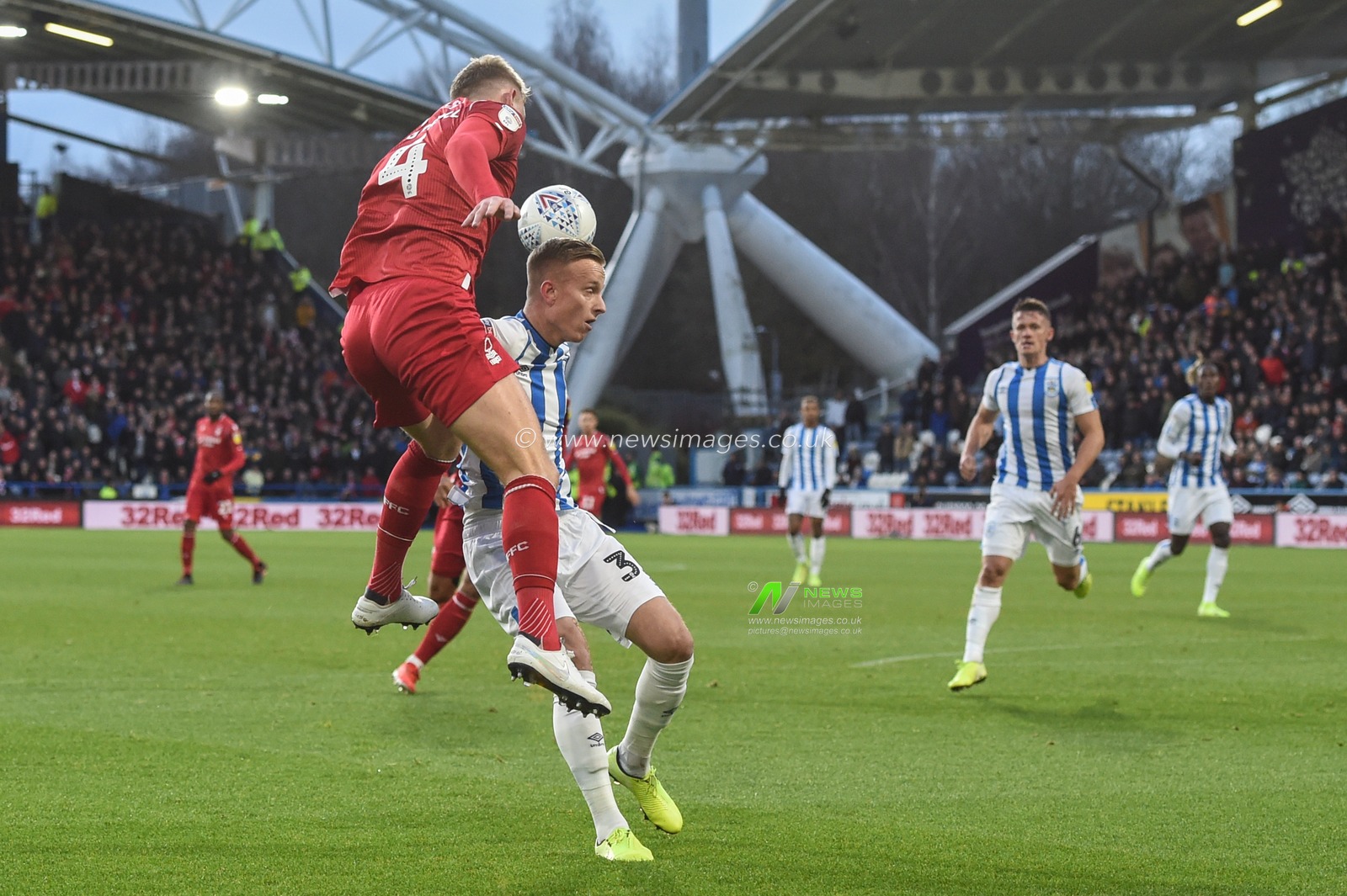 21st December 2019, John Smith's Stadium, Huddersfield, England; Sky Bet Championship, Huddersfield Town v Nottingham Forest :Joe Worrall (4) of Nottingham Forest takes the ball despite the attention of Florent Hadergjonaj (33) of Huddersfield Town 

Credit: Dean Williams/News Images