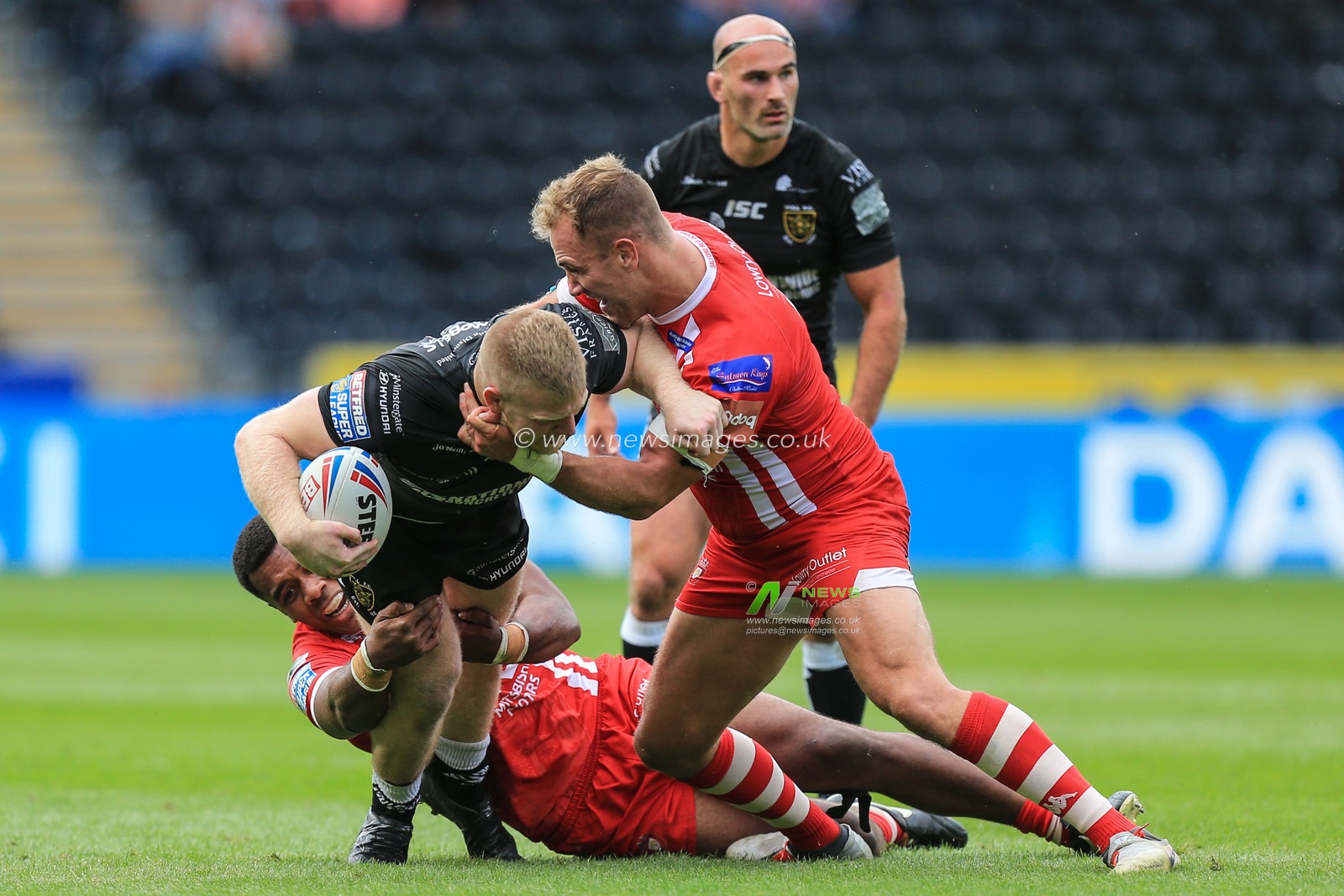 17th August 2019 , KCOM Stadium, Hull, England;  Betfred Super League, Round 26, Hull FC vs Salford Red Devils ; Brad Fash (20) of Hull FC is tackled by Ben Nakubuwai (18) and Lee Mossop (8) of Salford Red Devils 

Credit: David Greaves/News Images