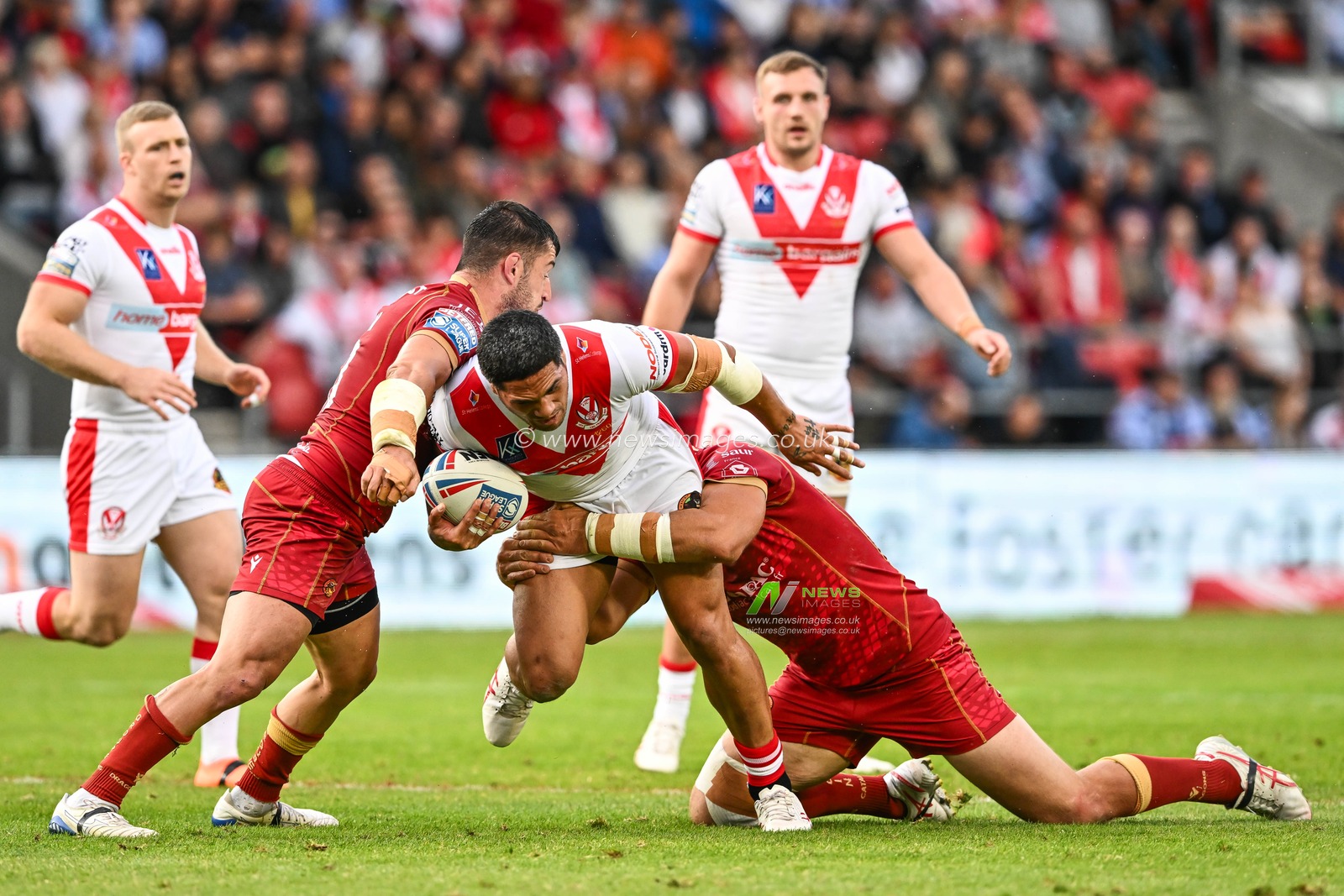 Sione Mataâ€™utia #11 of St Helens is tackled by Ben Garcia #13 and Matt Whitley #11 of Catalans Dragons during the Betfred Super League Round 19 match St Helens vs Catalans Dragons at Totally Wicked Stadium, St Helens, United Kingdom, 13th July 2023

(Photo by Craig Thomas/News Images)