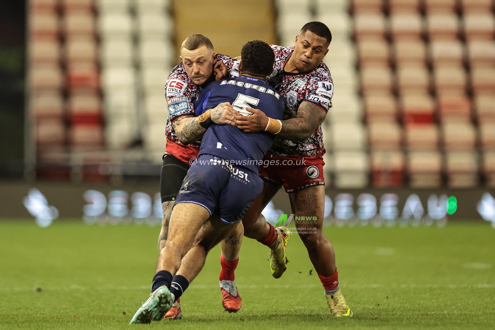 Benjamin Laguerre of Toulouse Olympique is tackled by Josh Charnley of Leigh Leopards and Tesi Niu of Leigh Leopards during the Betfred Super League round 6 match Leigh Leopards vs Toulouse at Leigh Sports Village, Leigh, United Kingdom on 28 March 2026

(Photo by Mark Cosgrove/News Images)