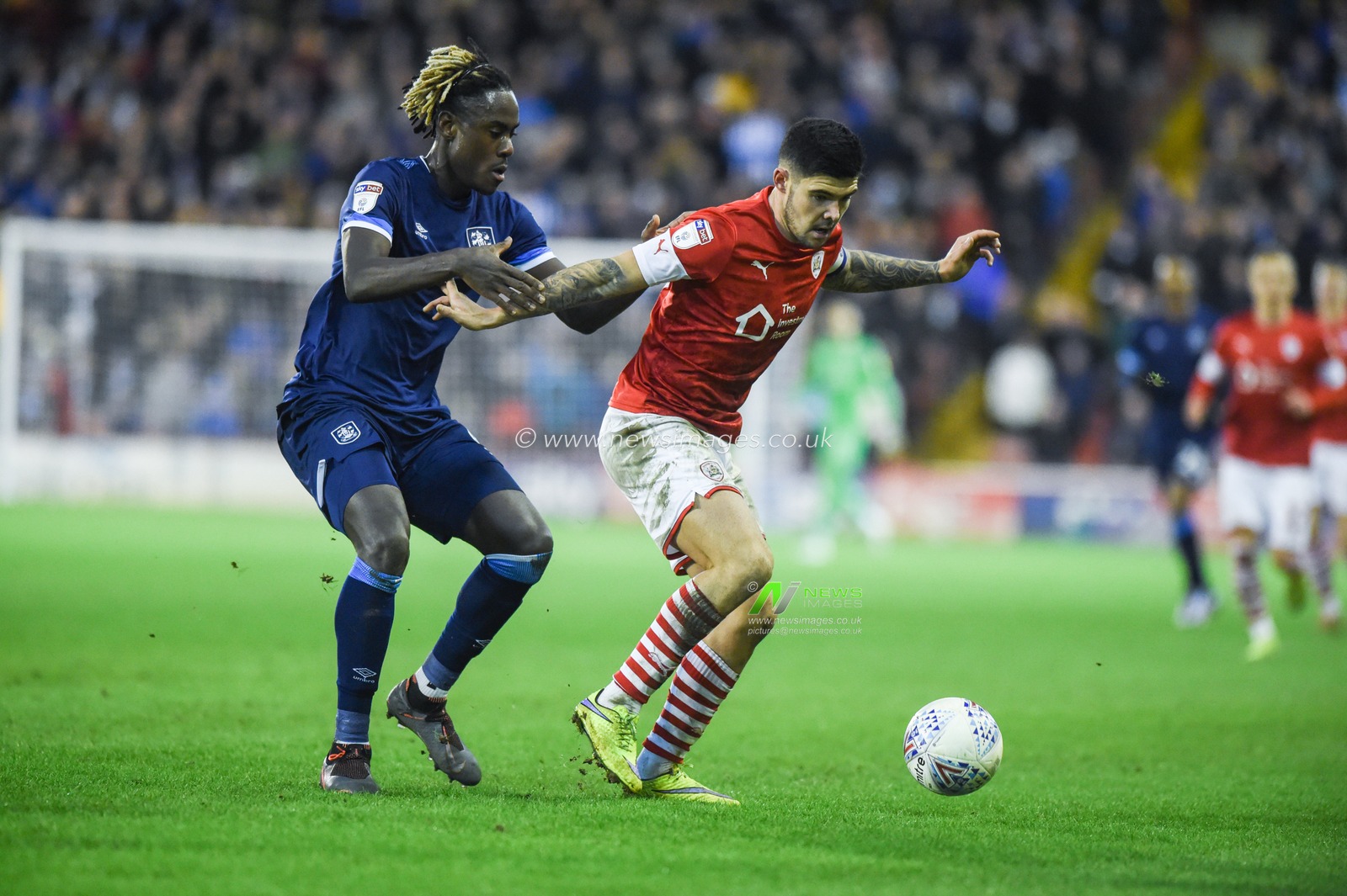 11th January 2020, Oakwell, Barnsley, England; Sky Bet Championship, Barnsley v Huddersfield Town : Alex Mowatt (27) of Barnsley FC holds off Trevor Chalabah (8) of Huddersfield Town

Credit: Dean Williams/News Images