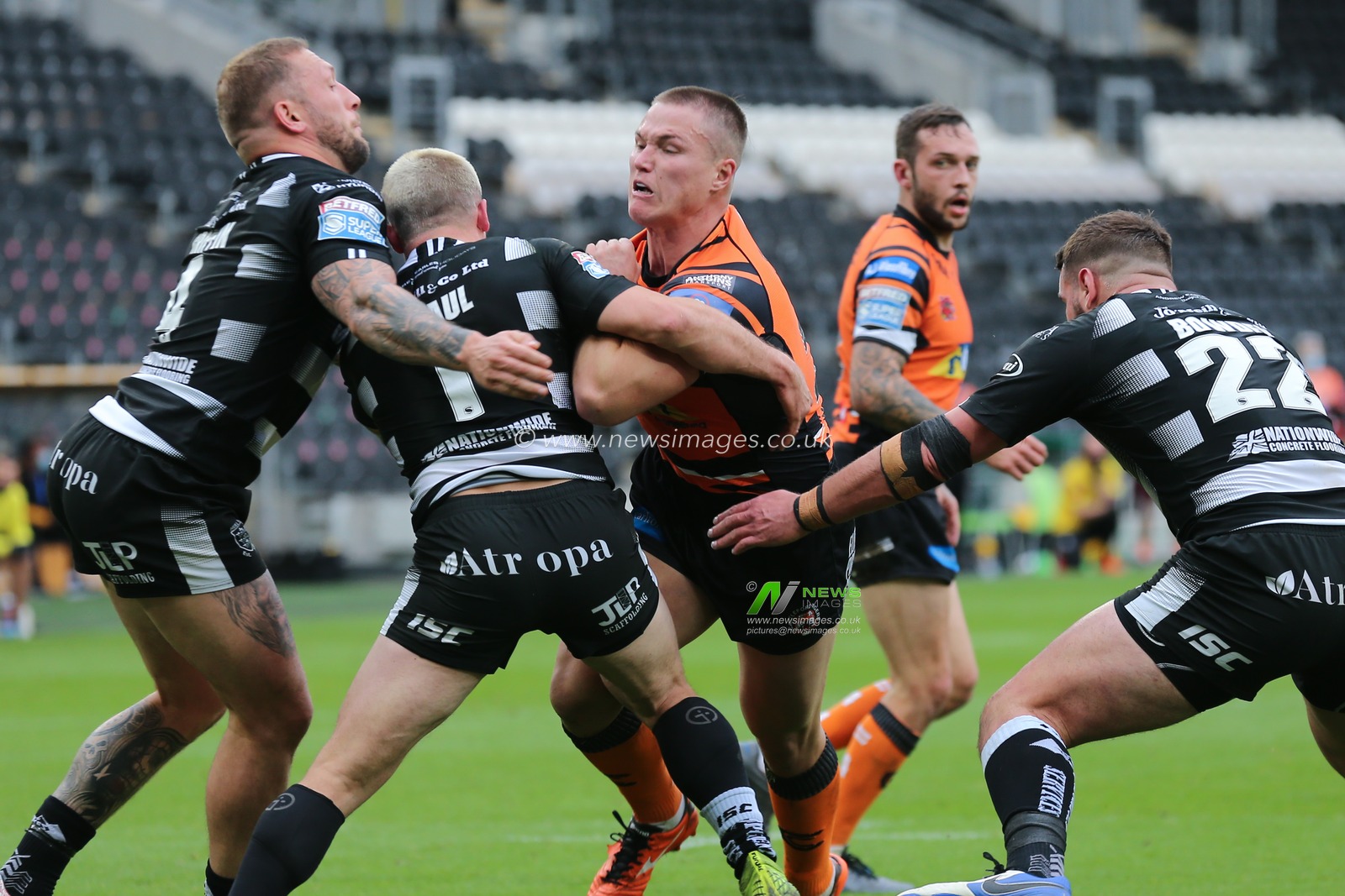 Tyla Hepi (24) of Castleford Tigers tackled by Josh Griffin (4, Jamie Shaul (1) and Josh Bowden (22) of Hull FC.