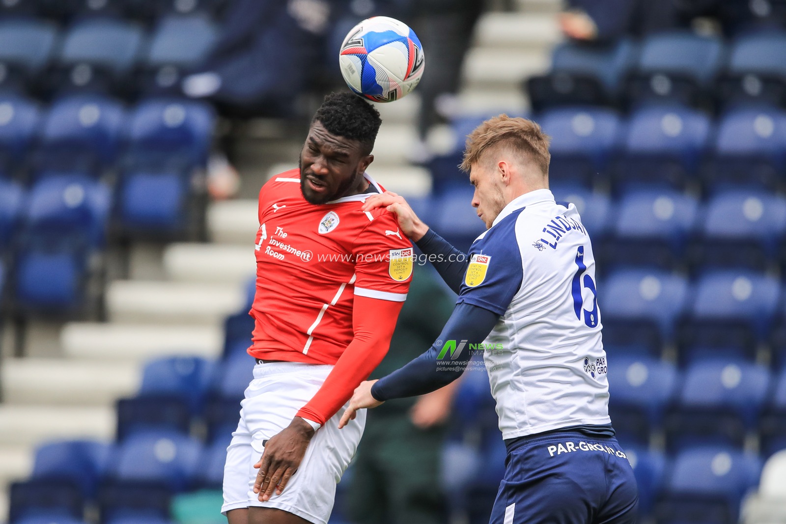 Daryl Dike #10 of Barnsley wins the high-ball from Liam Lindsay #6 of Preston North End