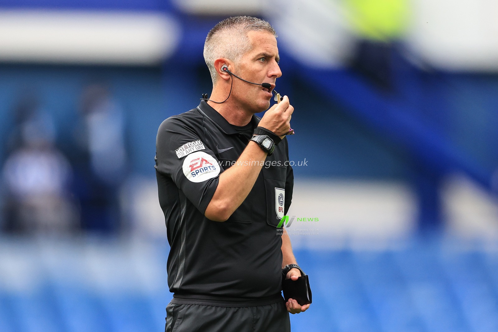 Referee Darren Bond  blows his whistle during the game