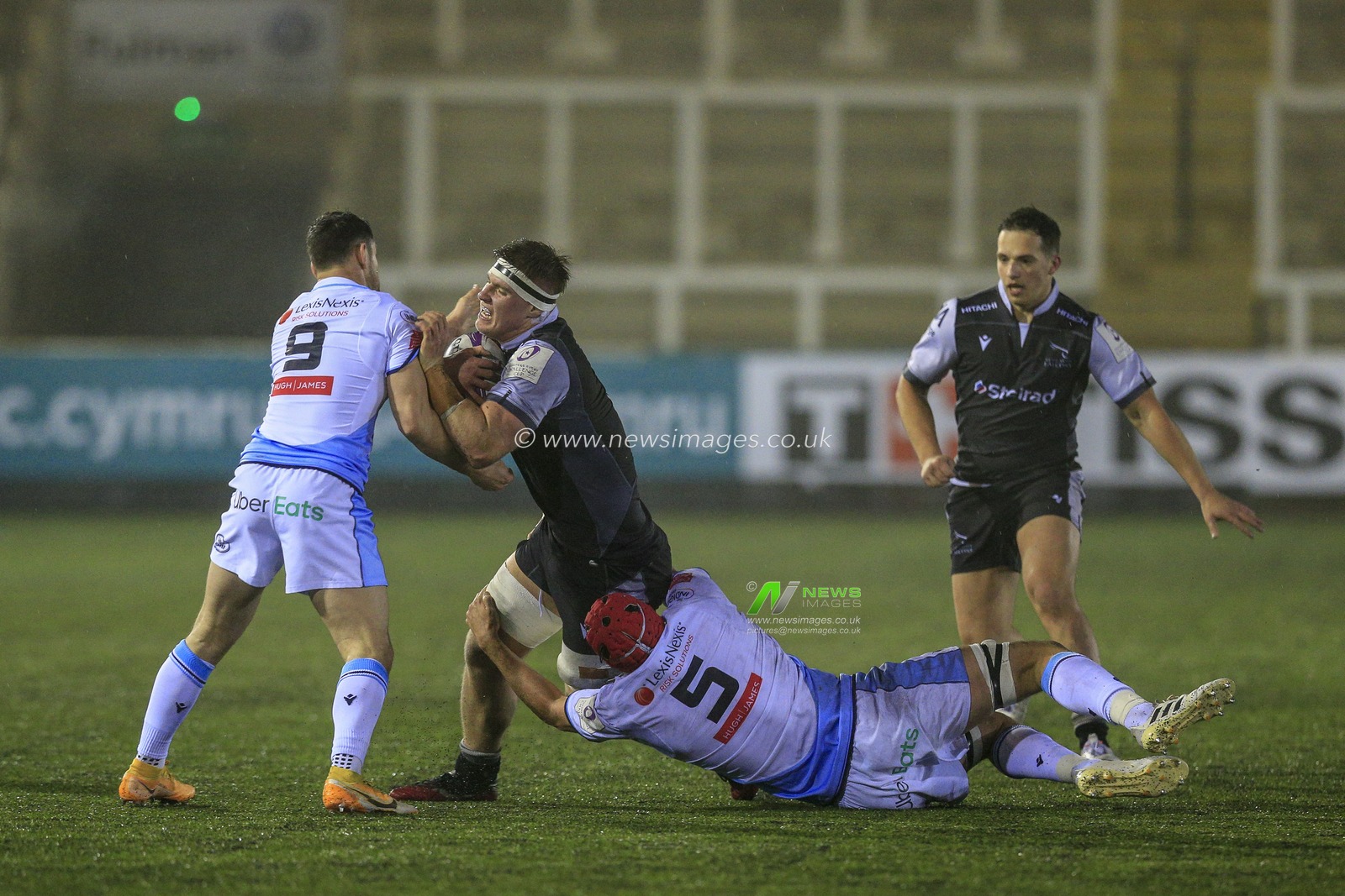 Rob Farrar of Newcastle Falcons is tackled by Cory Hill of Cardiff Blues and Tomos Williams of Cardiff Blues