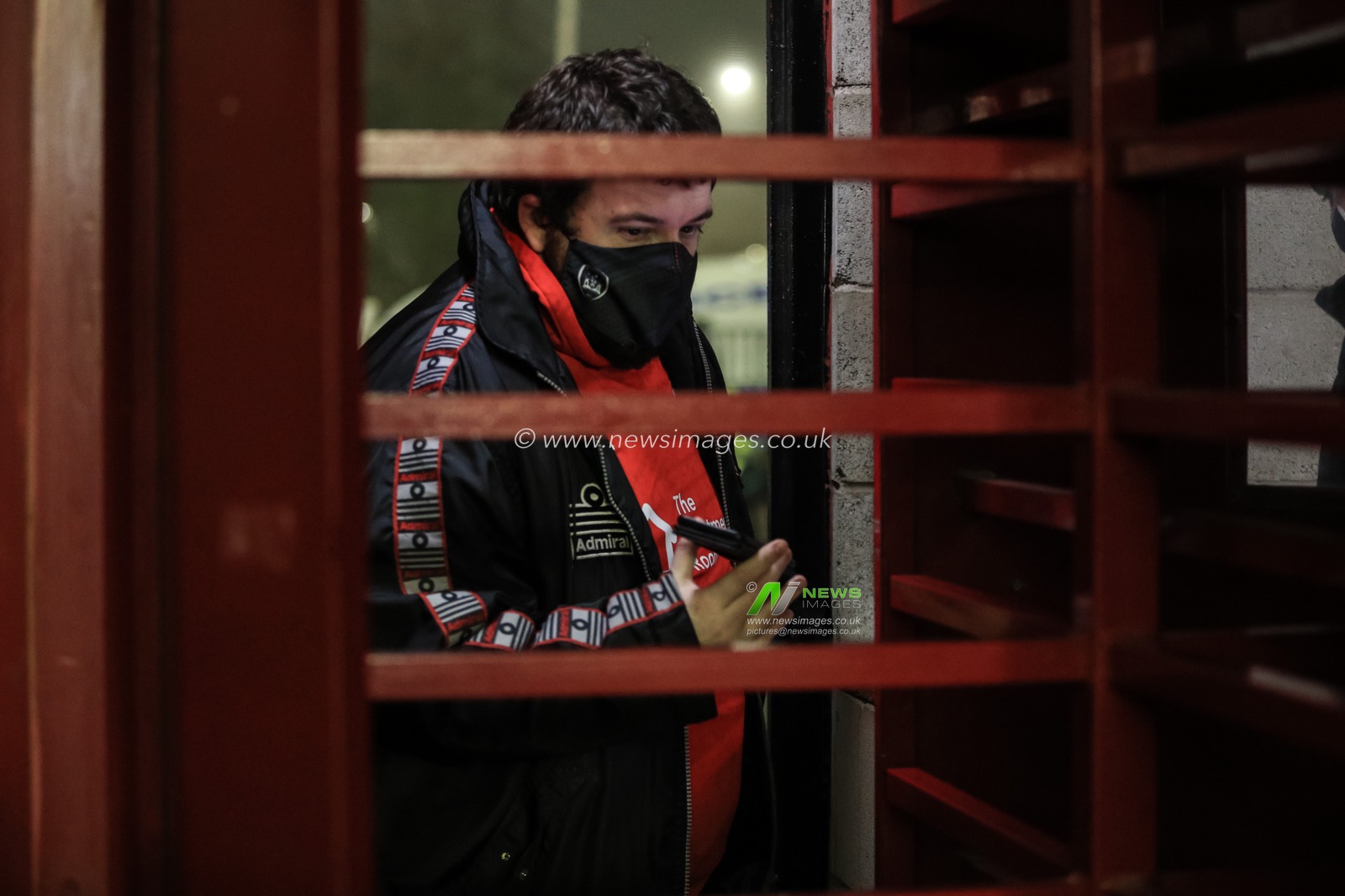 A Barnsley FC fan shows his Coronavirus (Covid-19) pass at the turnstiles after new restrictions are implemented across England