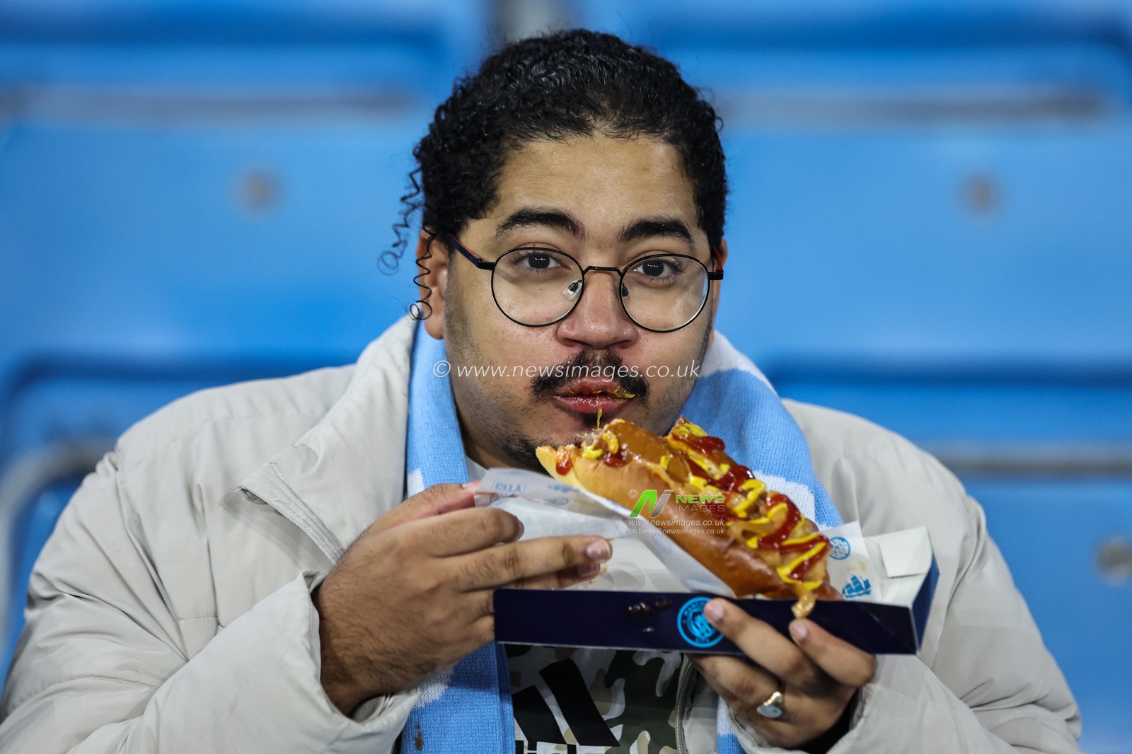 A Manchester City fan tucks into a giant hotdog covered in ketchup and mustard ahead of the UEFA Champions League, League Stage Manchester City v Sparta Prague at Etihad Stadium, Manchester, United Kingdom, 23rd October 2024

(Photo by Mark Cosgrove/News Images)