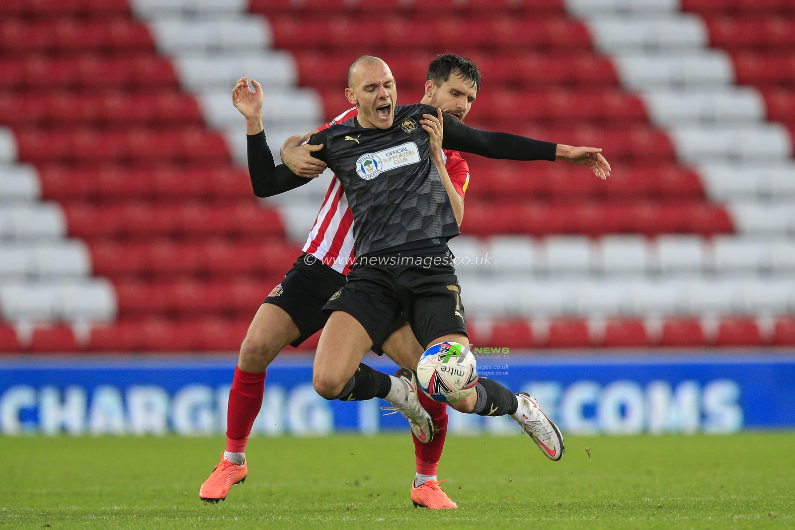 Kal Naismith #7 of Wigan Athletic is fouled by Bailey Wright #5 of Sunderland