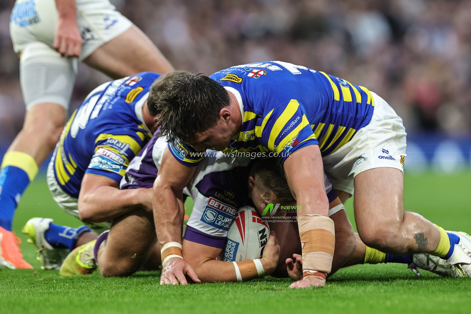 Cameron Scott of Wakefield Trinity is tackled by Liam Byrne of Warrington Wolves and Ben Currie of Warrington Wolves during the Betfred Super League Grand Final match Warrington Wolves vs Wakefield Trinity at Old Trafford, Manchester, United Kingdom on 03 October 2026

(Photo by Mark Cosgrove/News Images)