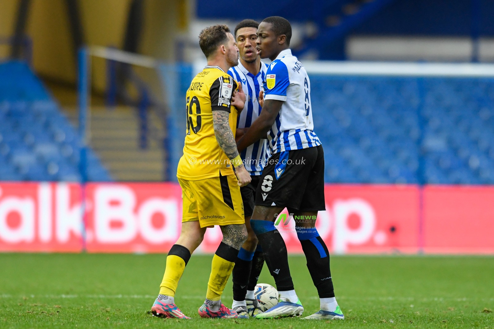 Dennis Adeniran #8 of Sheffield Wednesday and Chris Maguire #10 of Lincoln City clash on the pitch