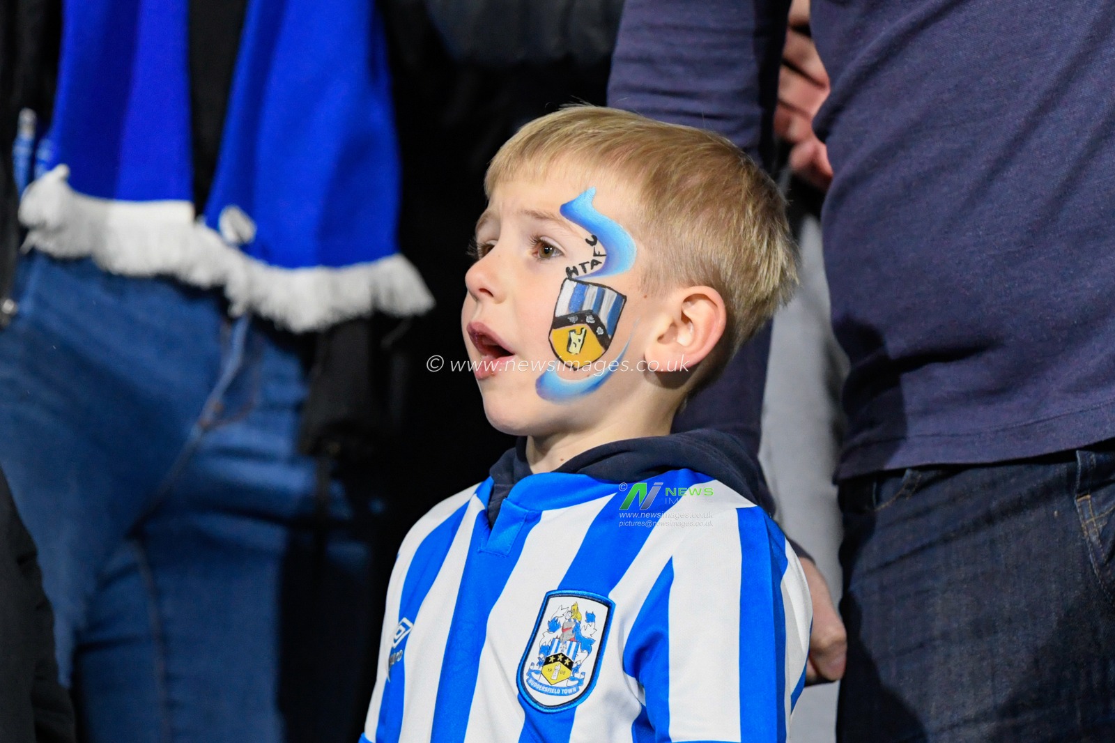 A young Huddersfield Town fan sings in support of his team
