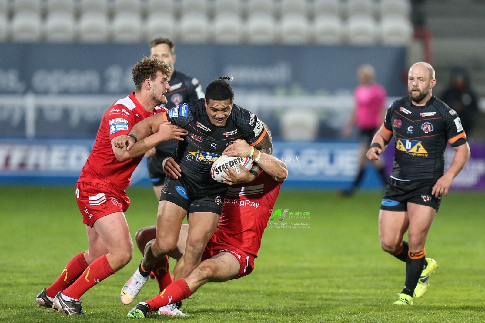 Peter Mata'utia (3) of Castleford Tigers is tackled by the Hull KR defence
