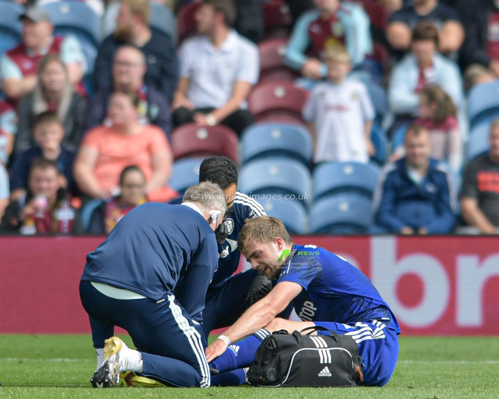 Patrick Bamford #9 of Leeds United receives treatment on the pitch after an injury