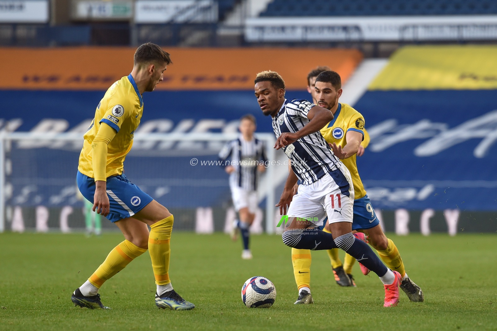 Grady Diangana #11 of West Bromwich Albion heads in to the challenge from Jakub Moder #15 of Brighton & Hove Albion