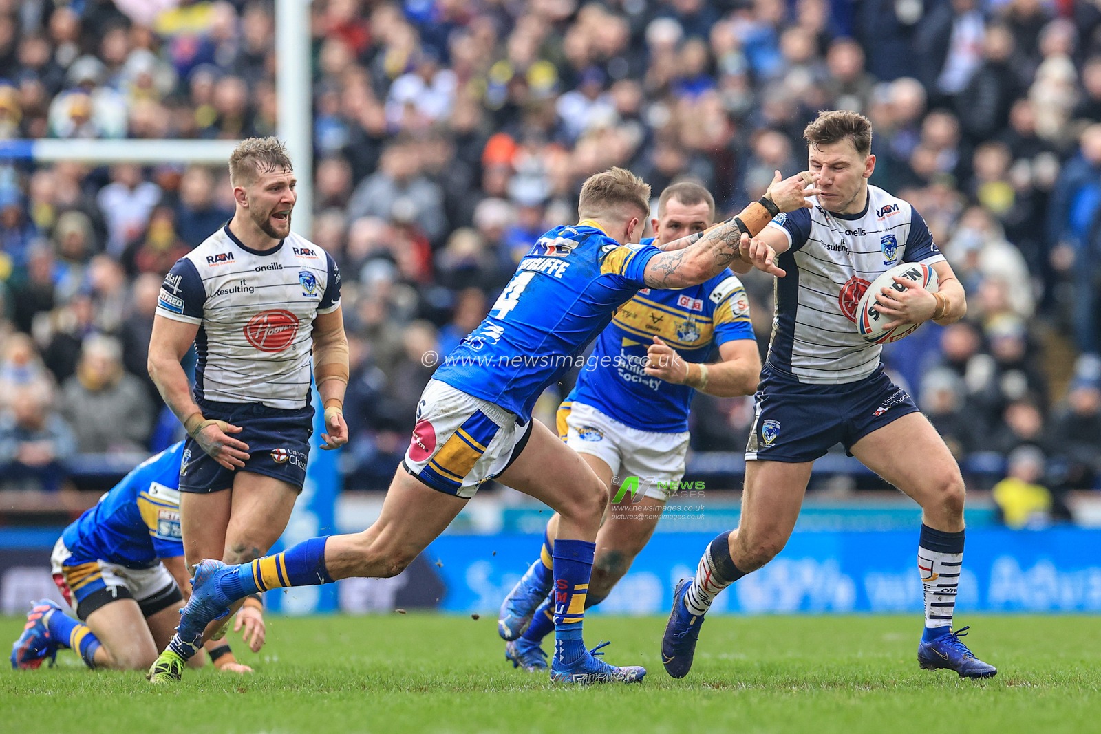George Williams #7 of Warrington Wolves holds off Liam Sutcliffe #4 of Leeds Rhinos