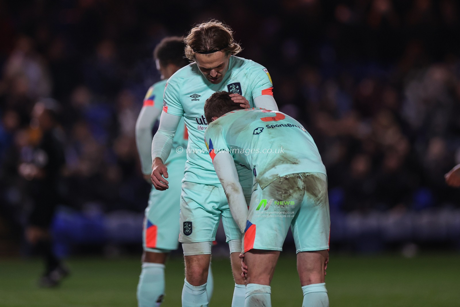 Danny Ward #25 of Huddersfield Town gives Harry Toffolo #3 of Huddersfield Town a pat on the back as he crouches