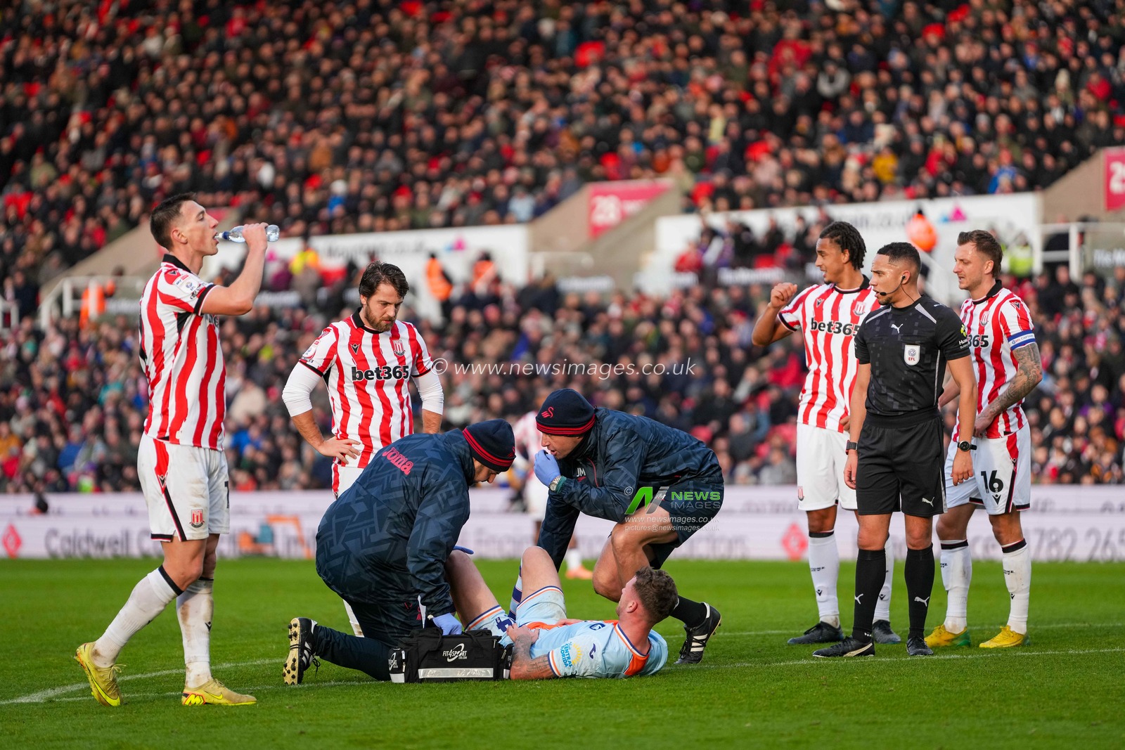 Jay Fulton of Swansea City receives treatment on the field as Stoke City players look on during the Sky Bet Championship match Stoke City vs Swansea City at Bet365 Stadium, Stoke-on-Trent, United Kingdom, 13th December 2025

(Photo by Maynard Manyowa/News Images)

*** GER AUT SUI OUT ***