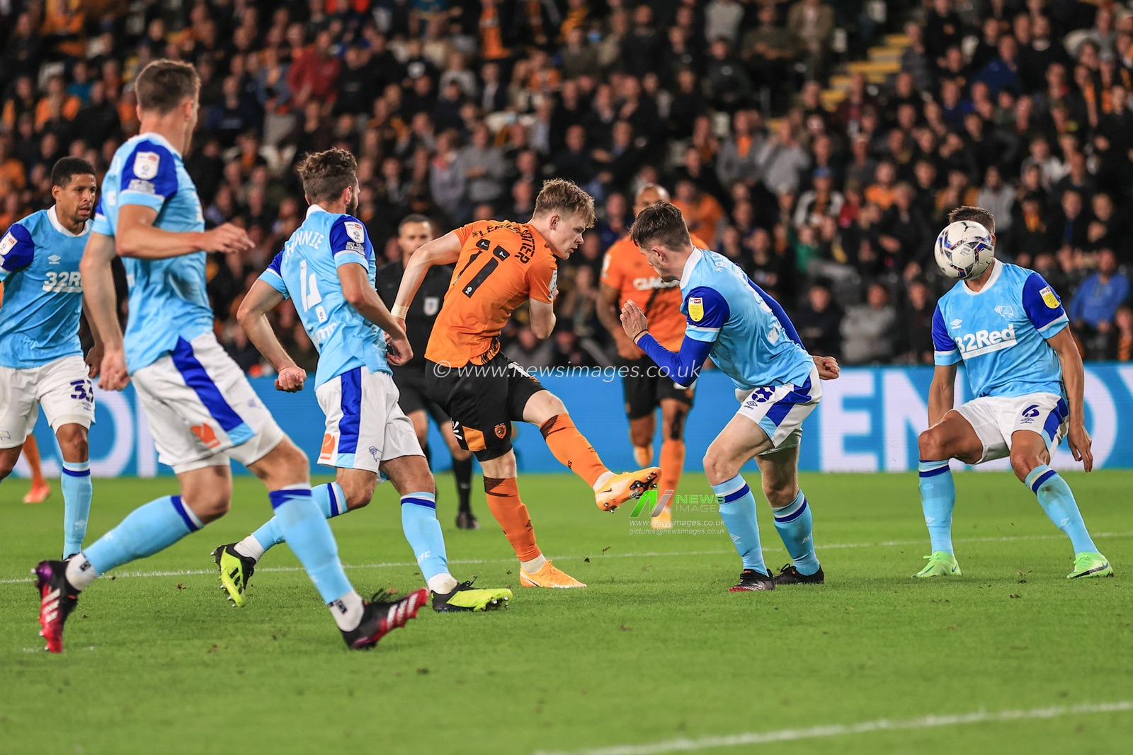 Keane Lewis-Potter #11 of Hull City shoots on goal, Kelle Roos #21 of Derby County puts the ball out for a corner