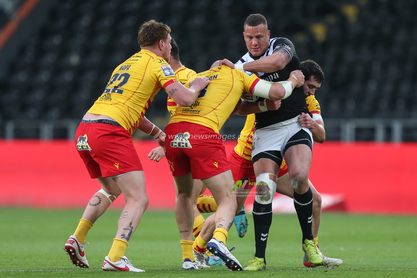 Kane Evans #16 of Hull FC is stopped by the Catalans defence