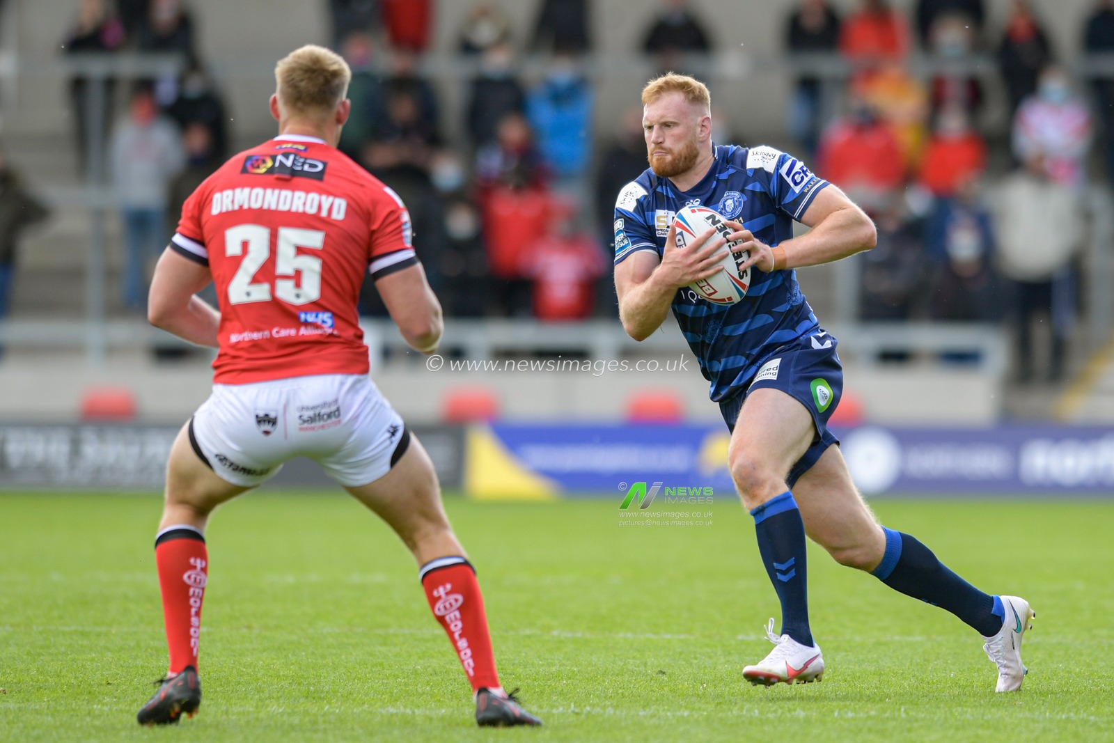Joe Bullock (10) of Wigan Warriors looks for a way past Jack Ormondroyd (25) of Salford Red Devils
