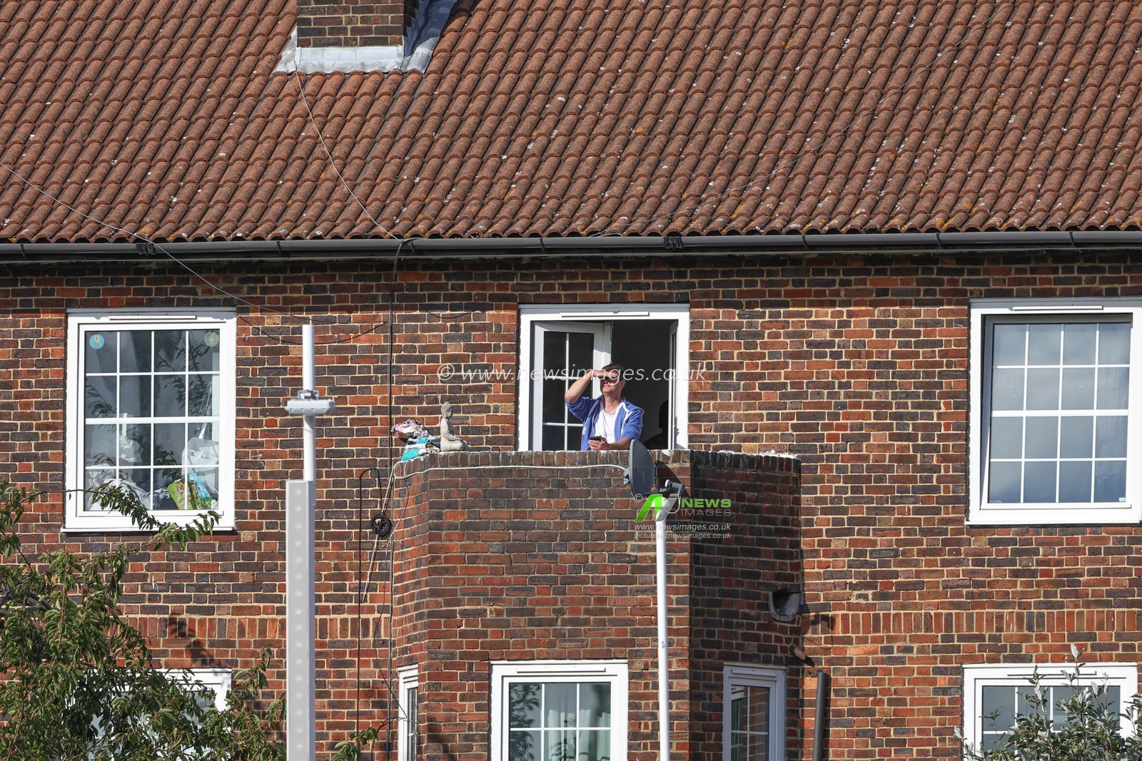 A person watches the cricket from a balcony of a house just behind the ground during the LV= Insurance Ashes Fifth Test Series Day Five England v Australia at The Kia Oval, London, United Kingdom, 31st July 2023

(Photo by Mark Cosgrove/News Images)