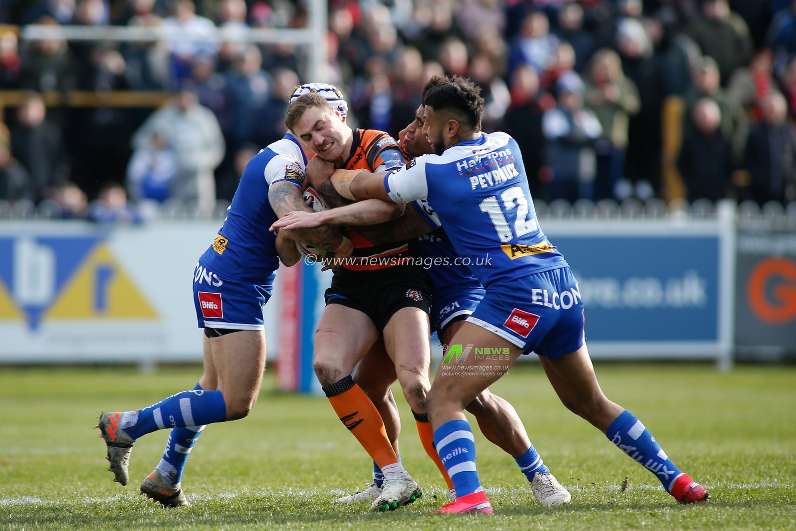 15th March 2020, The Mend-A-Hose Jungle, Castleford, England; Betfred Super League, Castleford Tigers v Saint Helens : James Clare of Castleford Tigers tackled by Dom Peyroux and Theo Fages of St Helens.