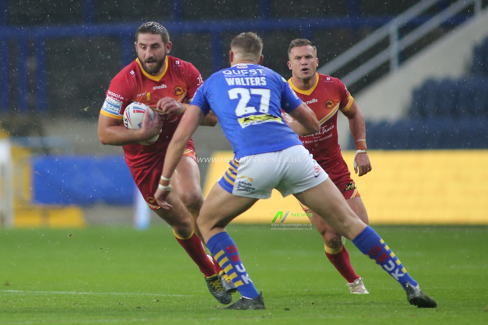 Julian Bousquet of Catalan Dragons tackled by Sam Walters (27) of Leeds Rhinos.