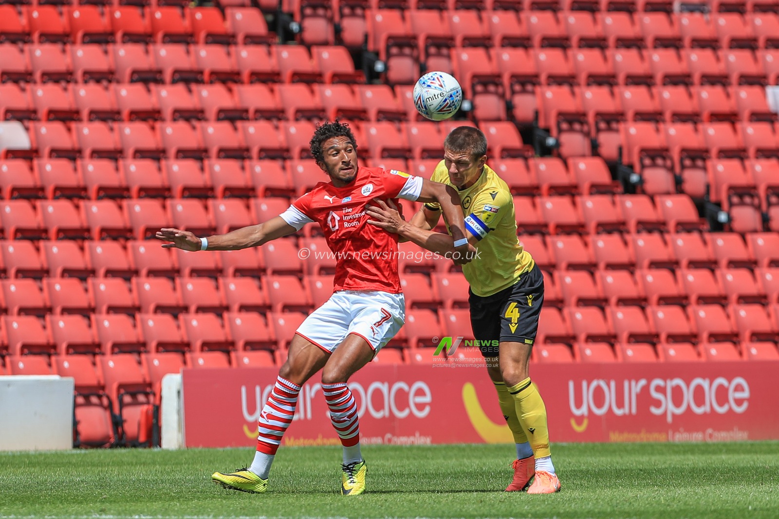 Shaun Hutchinson (4) of Millwall heads clear as Jacob Brown (7) of Barnsley challenges