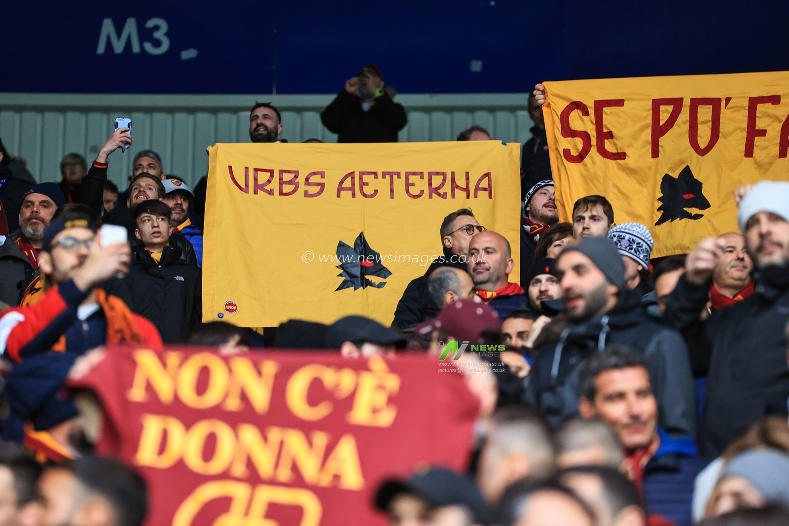 Roma fans hold up banners as they arrives at The King Power Stadium, Home of Leicester City