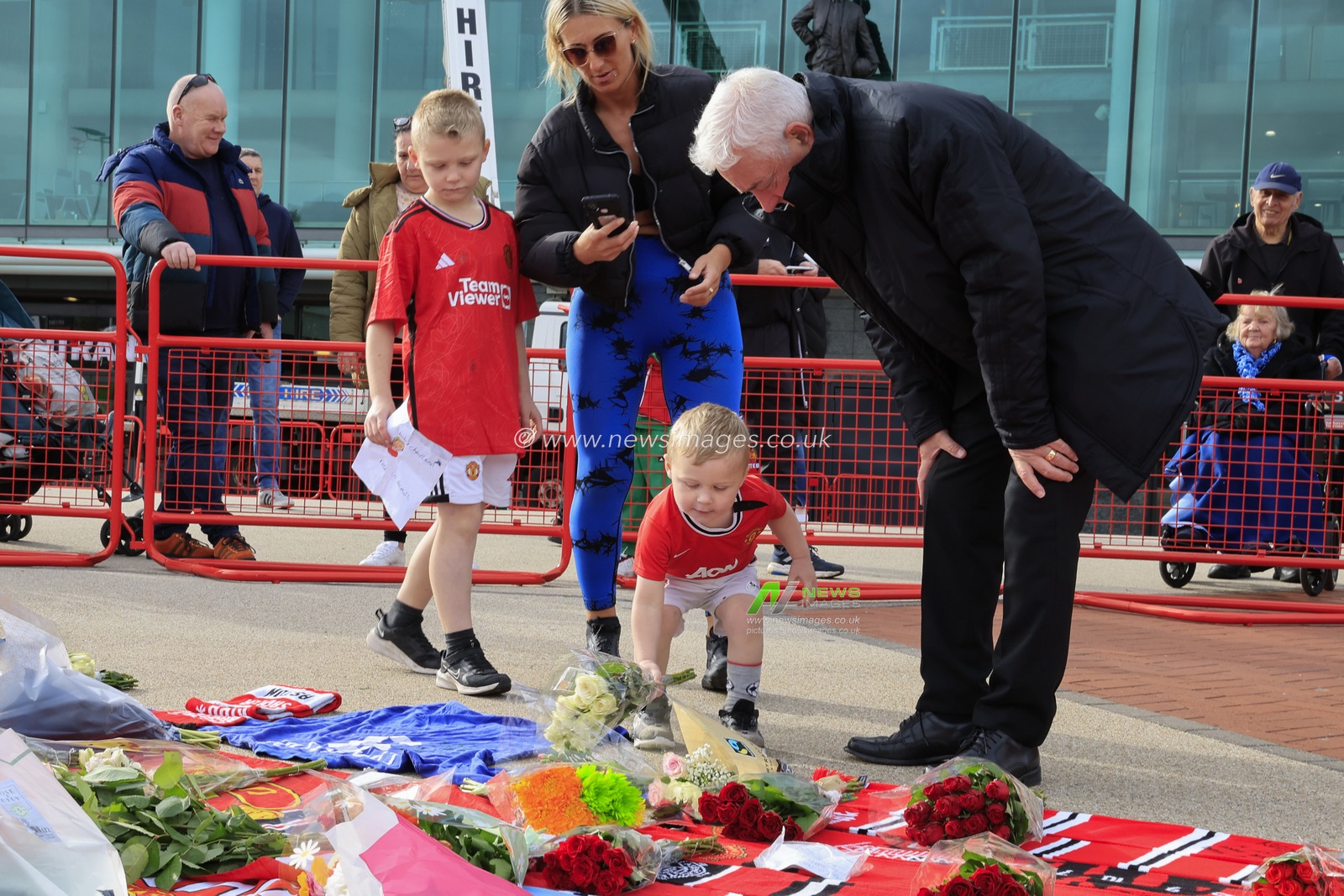A young fan leaves some flowers in tribute to the late Sir Bobby Charlton outside of Old Trafford, Manchester, United Kingdom, 23rd October 2023

(Photo by Conor Molloy/News Images)