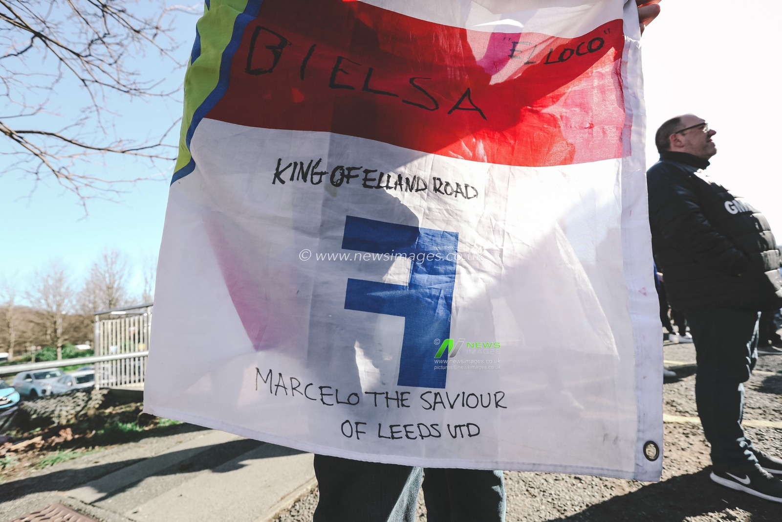 A Leeds United supporter holds a flag which reads â€˜Marcelo The Saviour Of Leeds UTDâ€™ outside Elland Road Stadium in support of Marcelo Bielsa after he was sacked by the club this morning