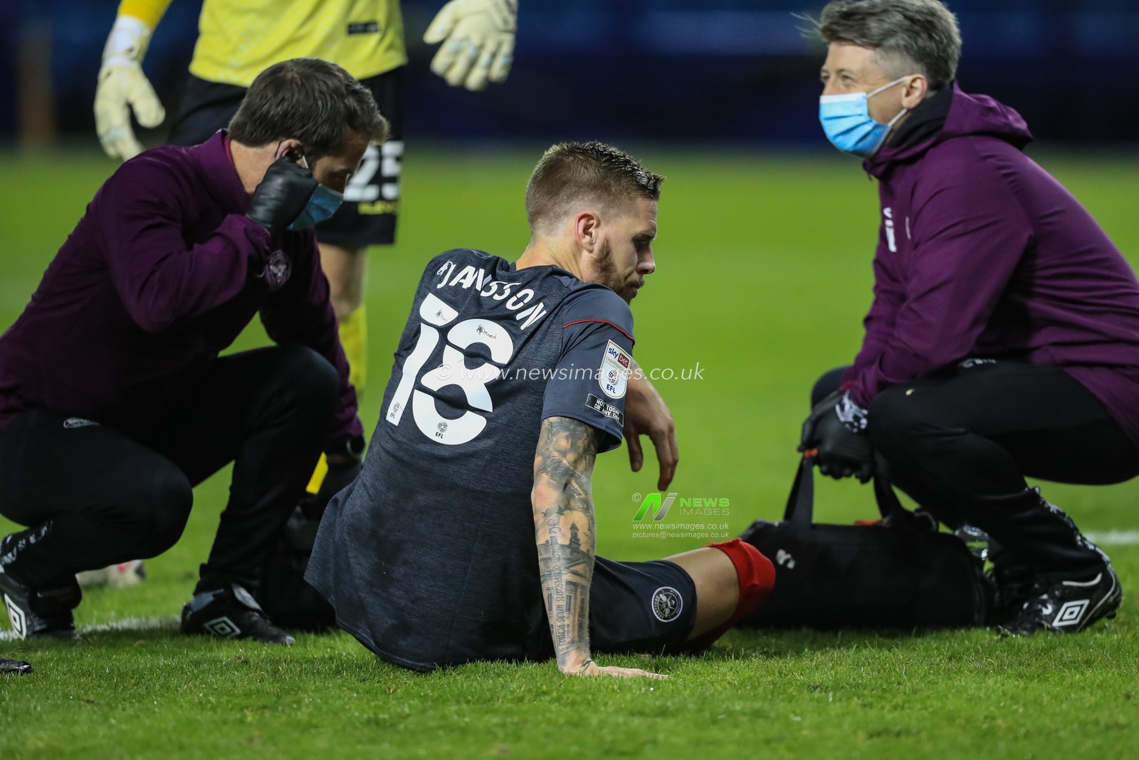 Pontus Jansson (18) of Brentford receives medical attention for a know injury