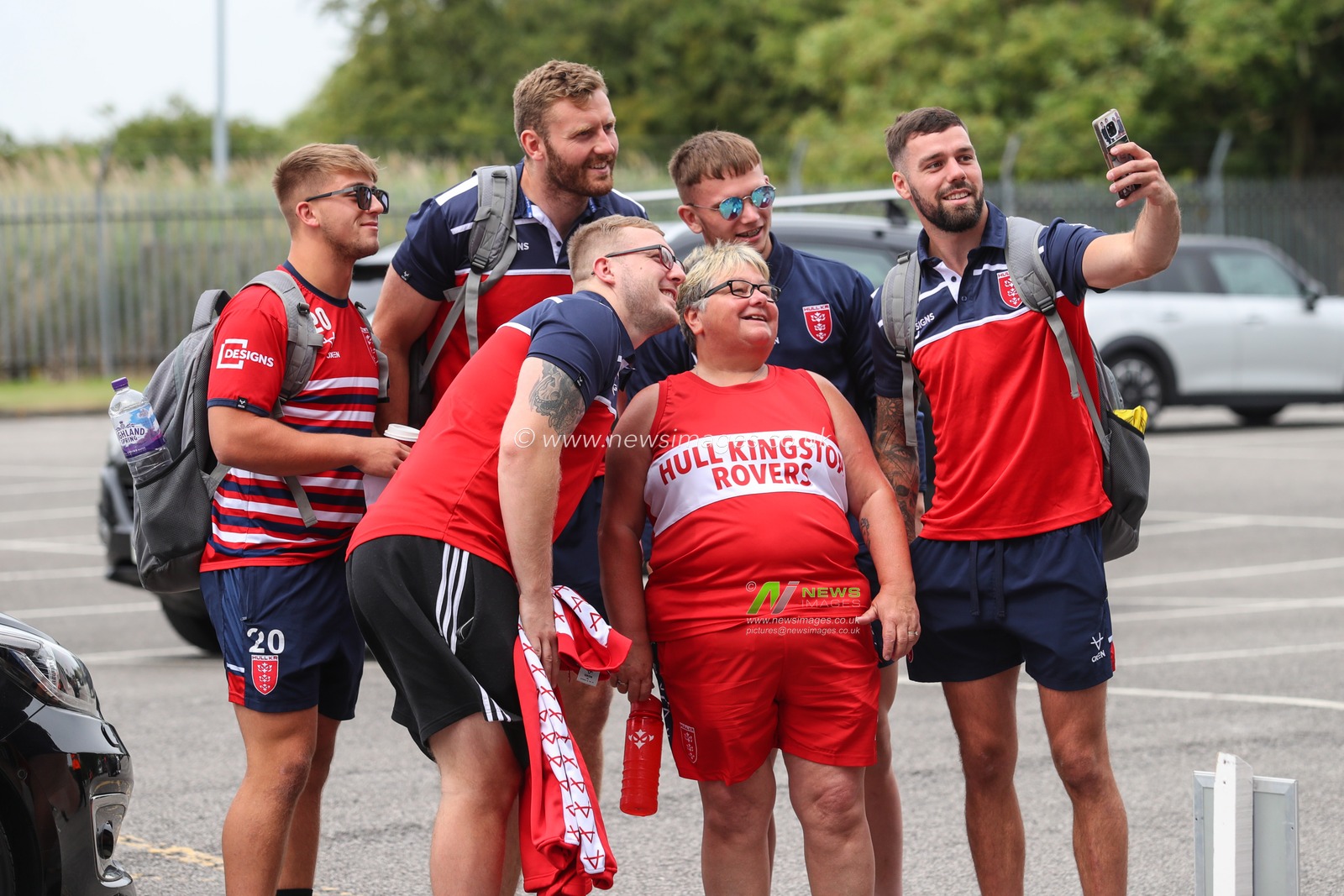 Hull Kingston Rovers players have a photograph taken with a fan