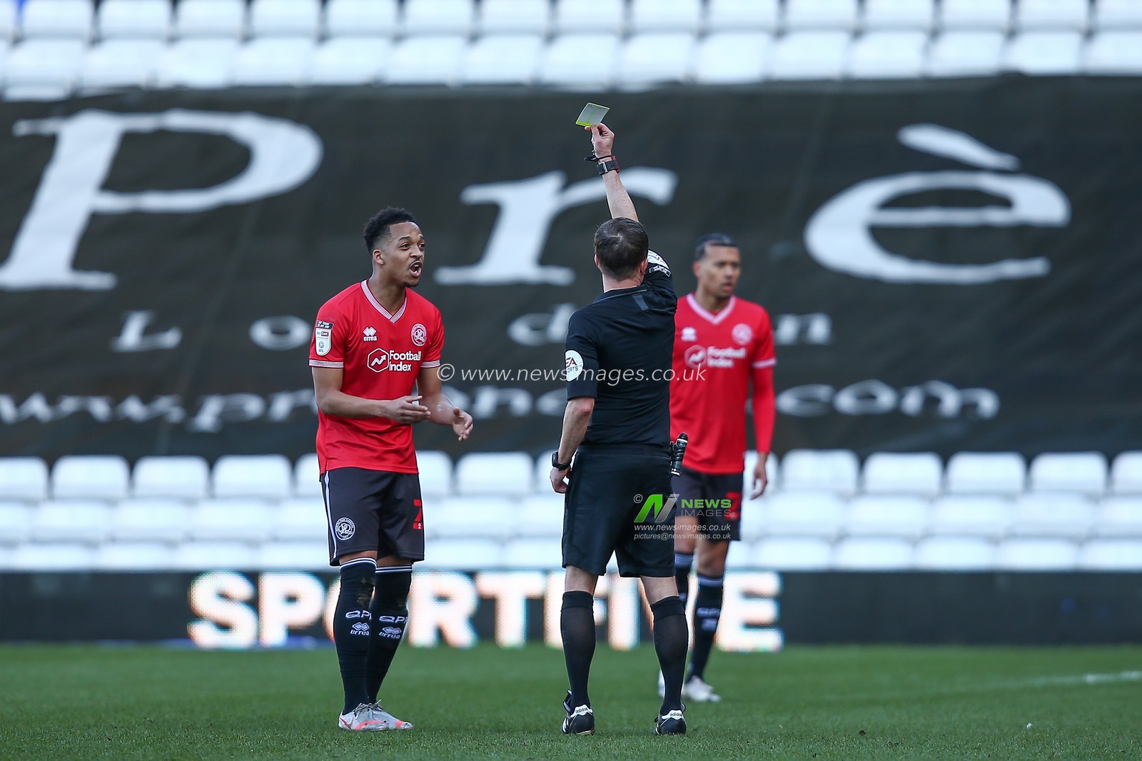 Chris Willock #21 of Queens Park Rangers receives a yellow card from Referee David Webb
