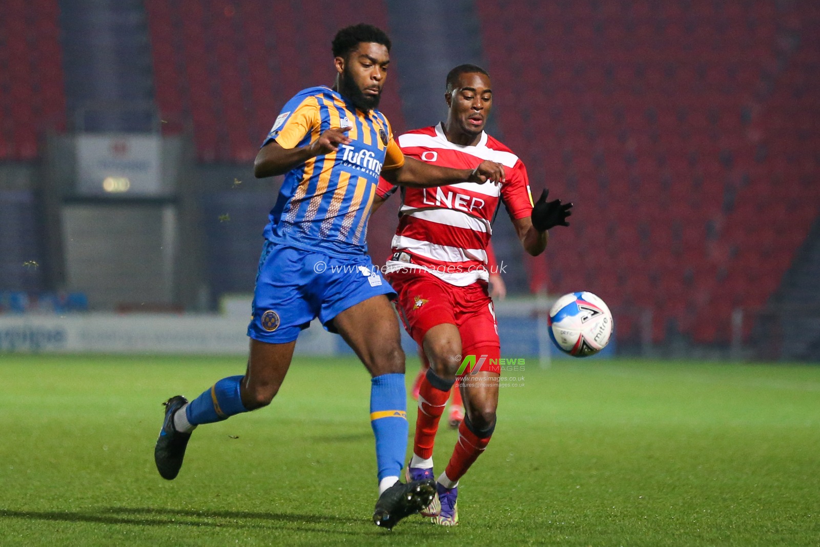 Fejiri Okenabirhie #9 of Doncaster Rovers and Ro-Shaun Williams #5 of Shrewsbury Town battle for possession