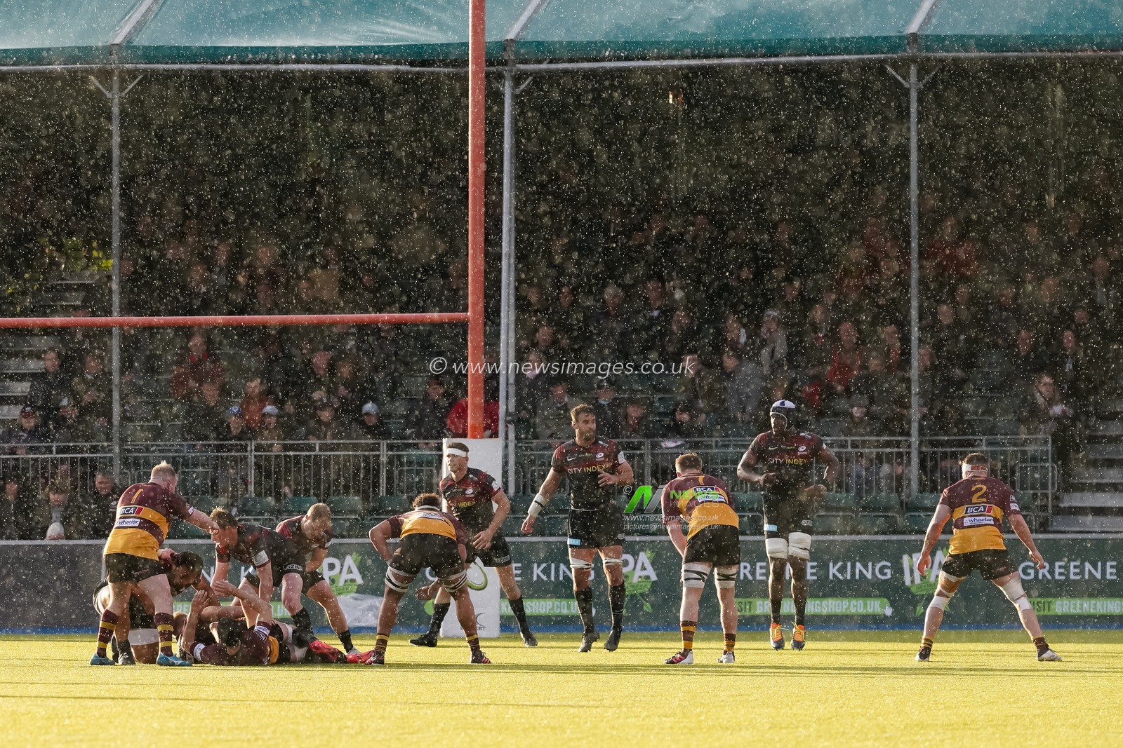 Saracens and Ampthill playing in the rain watched by the fans