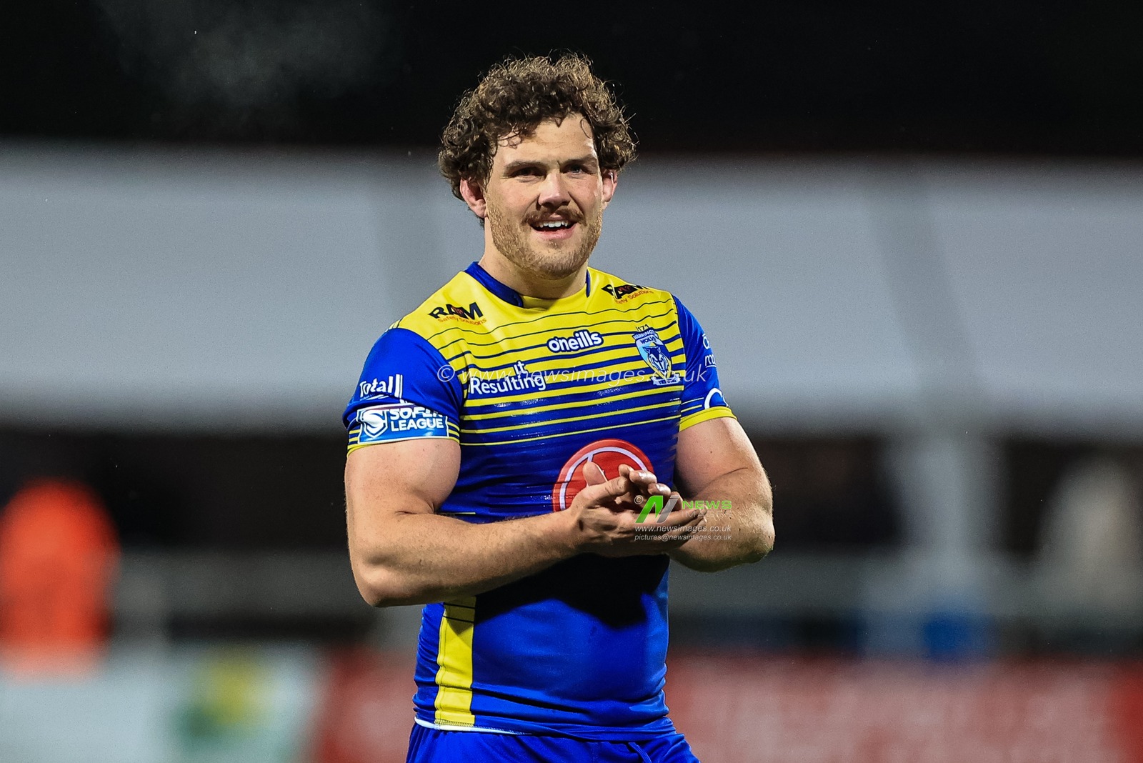 Rob Mulhern #19 of Warrington Wolves applauds the traveling fans