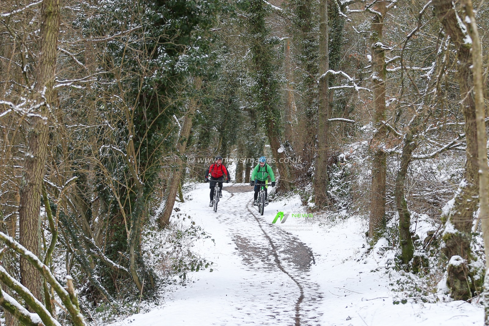 cyclists are seen riding on an icy path