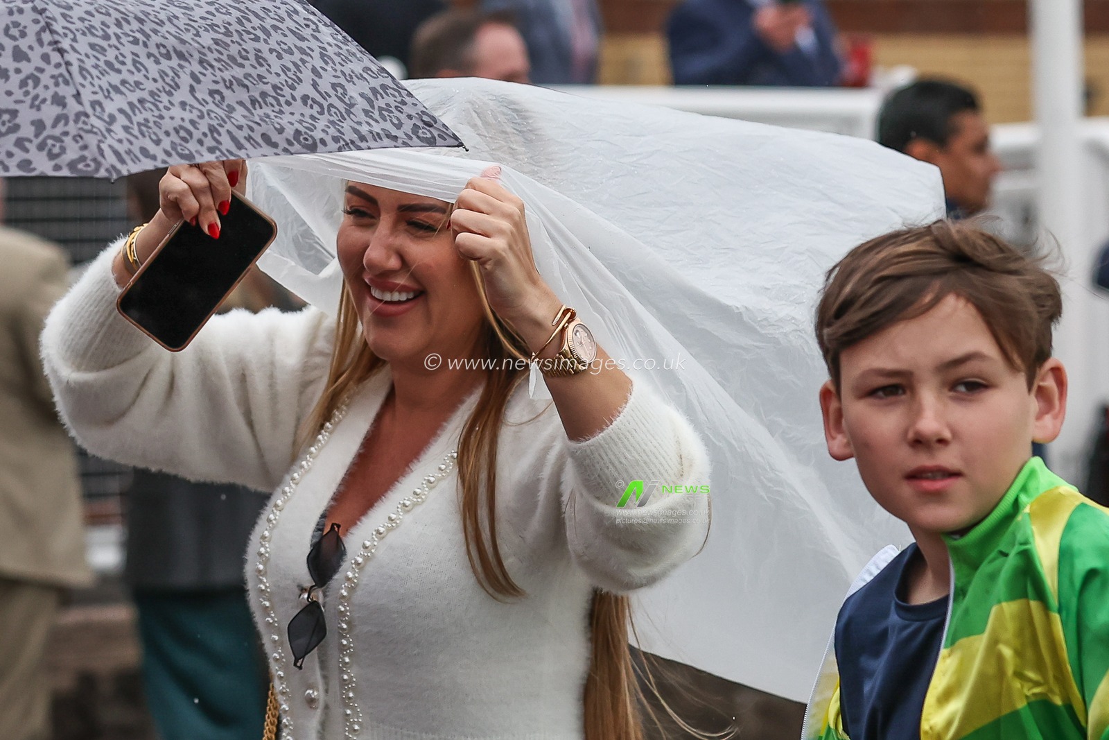 A racergoer takes cover as it begins to rain during the Randox Grand National 2024 Opening Day at Aintree Racecourse, Liverpool, United Kingdom, 11th April 2024

(Photo by Mark Cosgrove/News Images)