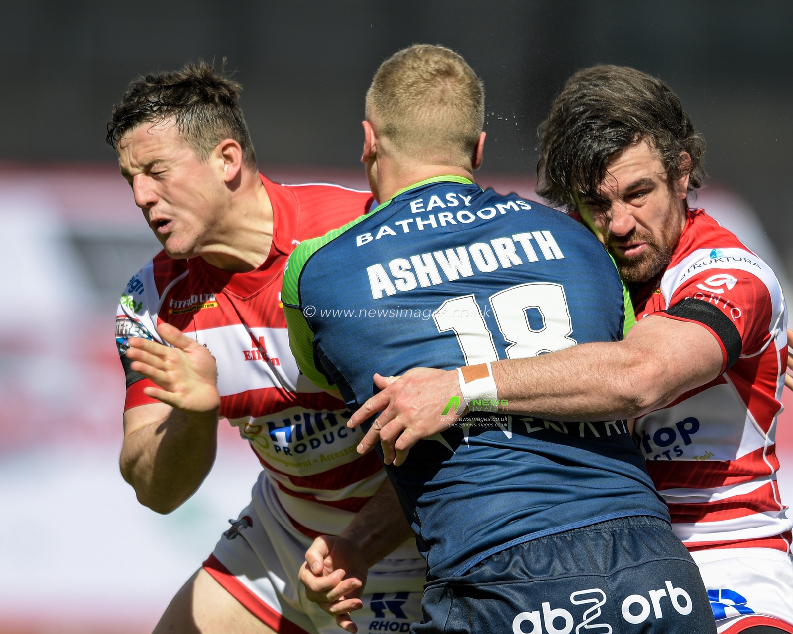 Jack Ashworth (18) of Huddersfield Giants is tackled by Matty Gee (18) of Leigh Centurions and Tyrone McCarthy (21) of Leigh Centurions