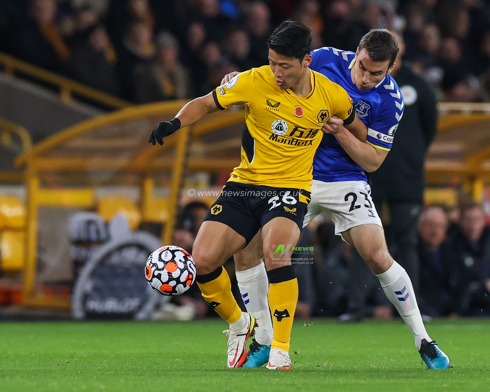 Hwang Hee-chan #26 of Wolverhampton Wanderers holds off Seamus Coleman #23 of Everton