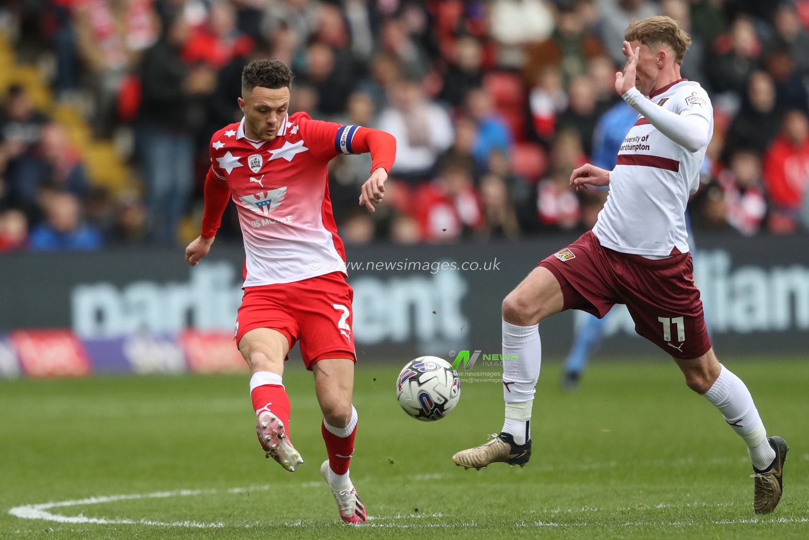 Jordan Williams of Barnsley clears the ball pressured by Mitch Pinnock of Northampton Town during the Sky Bet League 1 match Barnsley vs Northampton Town at Oakwell, Barnsley, United Kingdom, 27th April 2024

(Photo by Alfie Cosgrove/News Images)