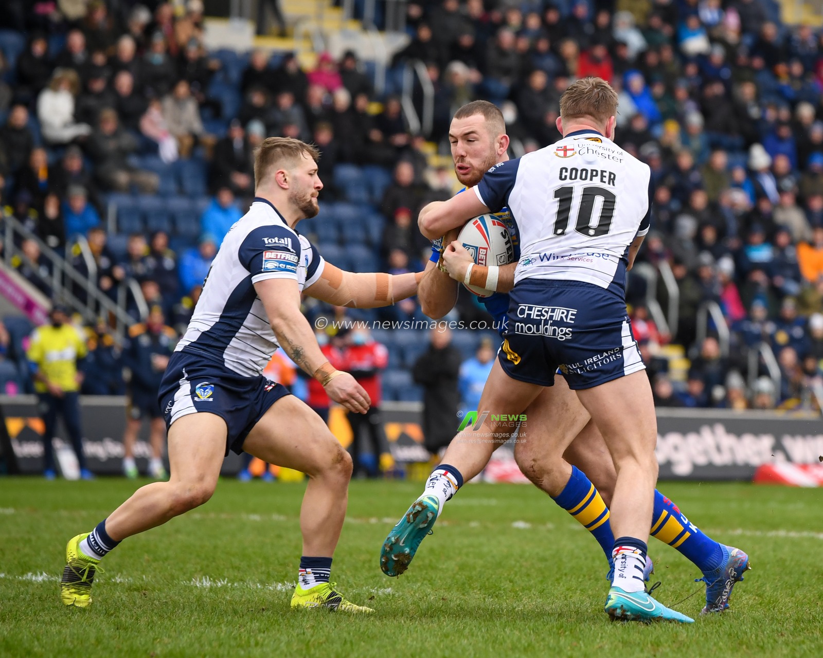 Cameron Smith #17 of Leeds Rhinos looks for a way past Mike Cooper #10 and Matt Davis #17 of Warrington Wolves