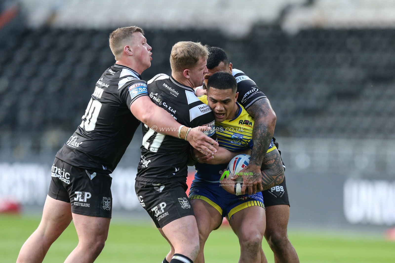 Peter Mataâ€™utia #3 of Warrington Wolves is stopped by the Hull FC defence