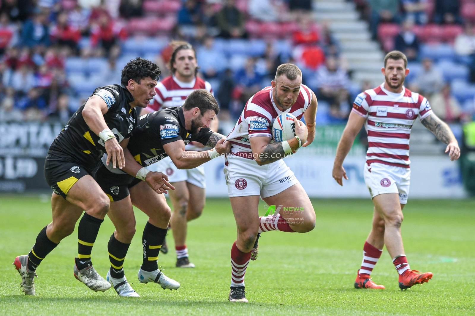 Kaide Ellis #15 of Wigan Warriors starts an attacking move