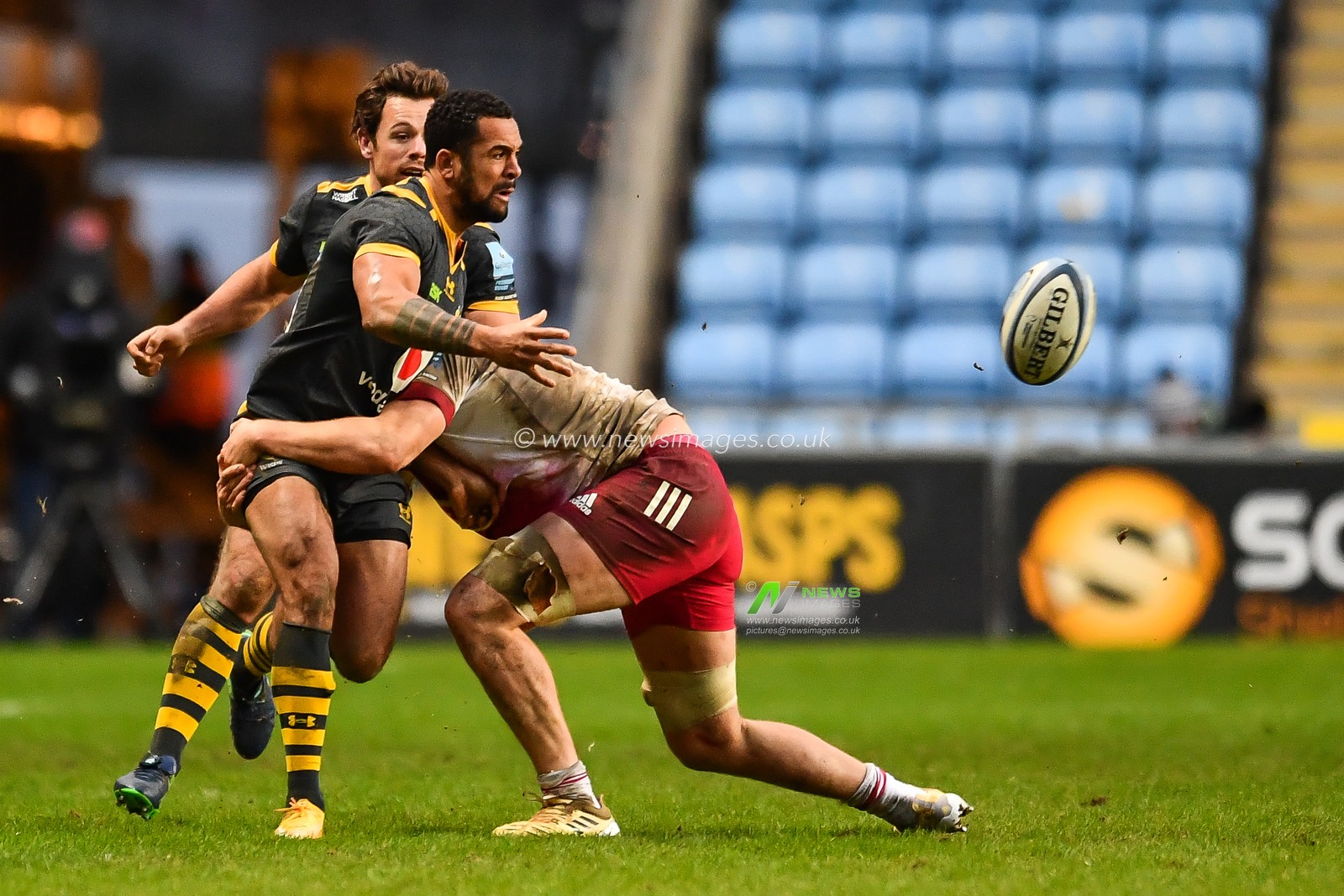 Zach Kibirige of Wasps offloads despite the tackled by Alex Dombrandt of Harlequins