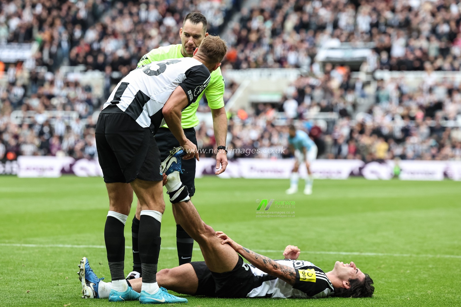 Dan Burn of Newcastle United helps Sandro Tonali of Newcastle United due to leg cramps during the Premier League match Newcastle United vs Manchester City at St. James's Park, Newcastle, United Kingdom, 28th September 2024

(Photo by Mark Cosgrove/News Images)