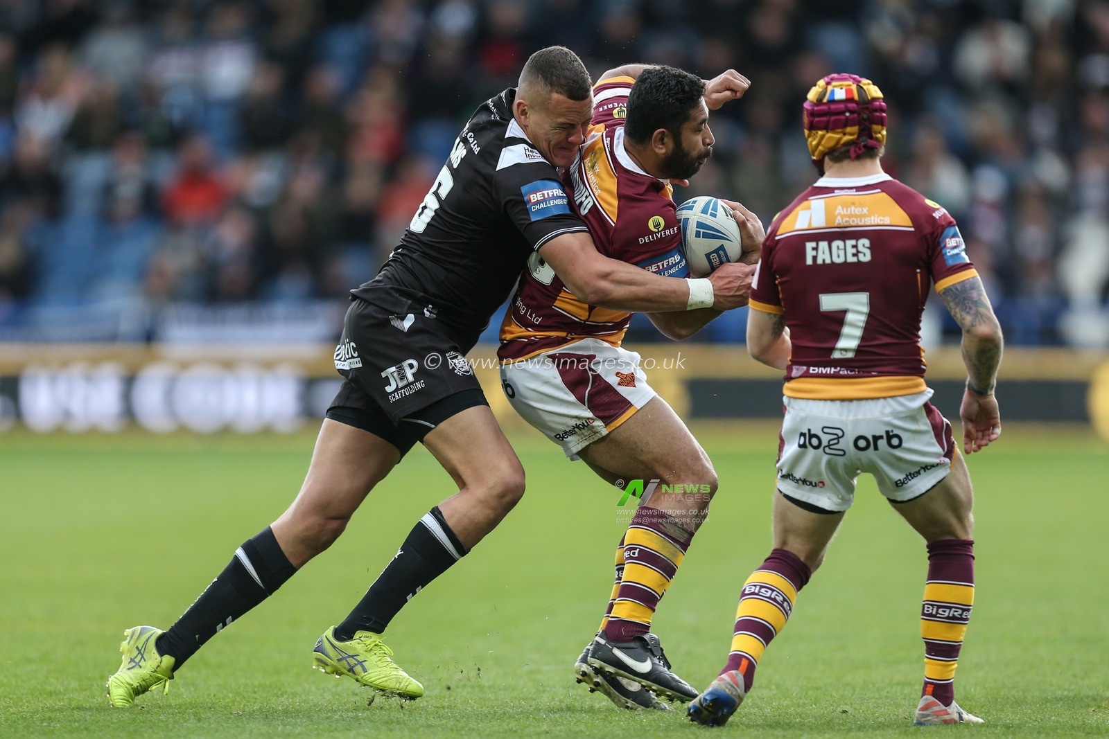 Kane Evans #16 of Hull FC tackles Sebastine Ikahihifo #18 of Huddersfield Giants