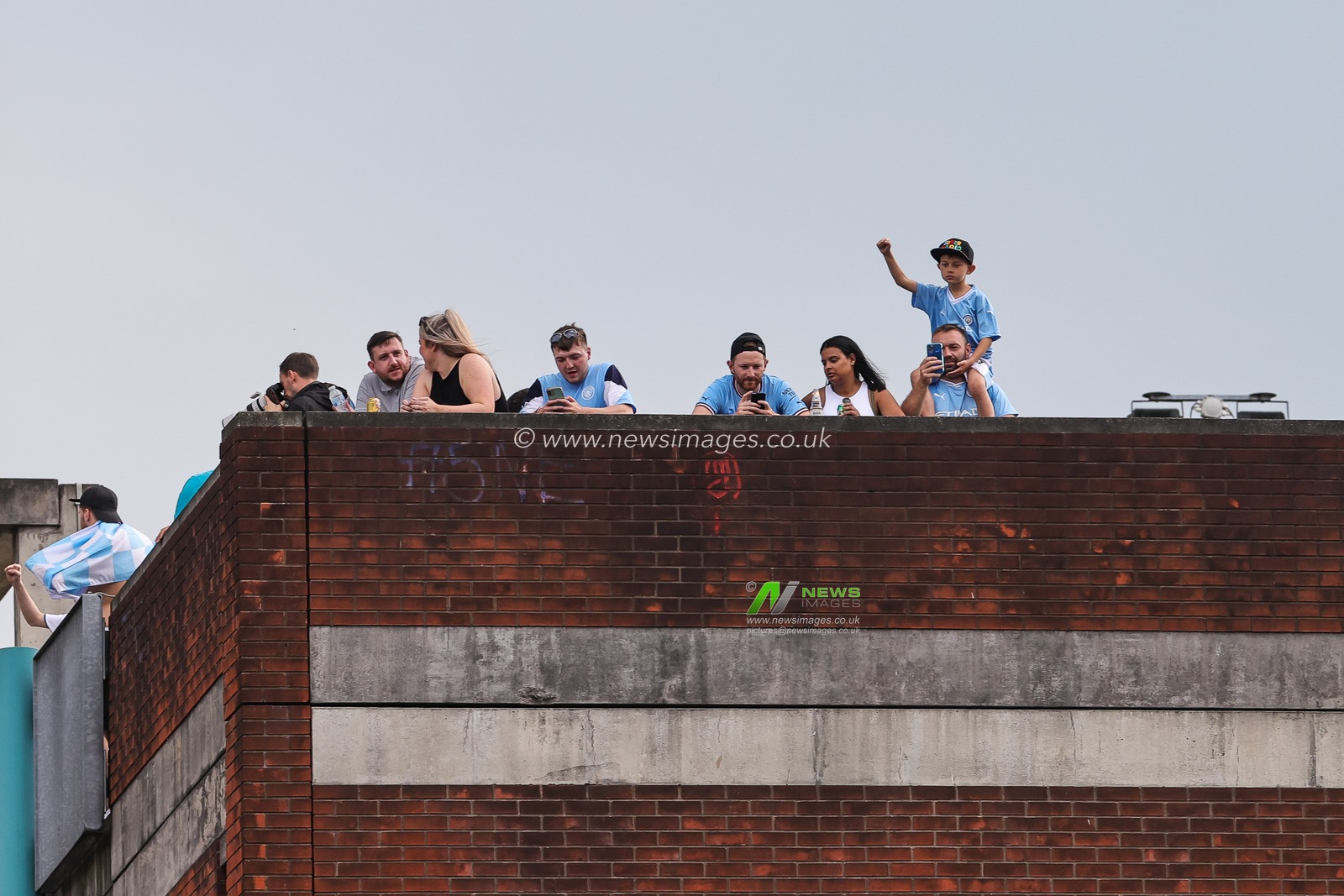 Manchester City fans on roof tops to watch the Manchester City's Treble victory parade at St Peterâ€™s Square, Manchester, United Kingdom, 12th June 2023

(Photo by Mark Cosgrove/News Images)